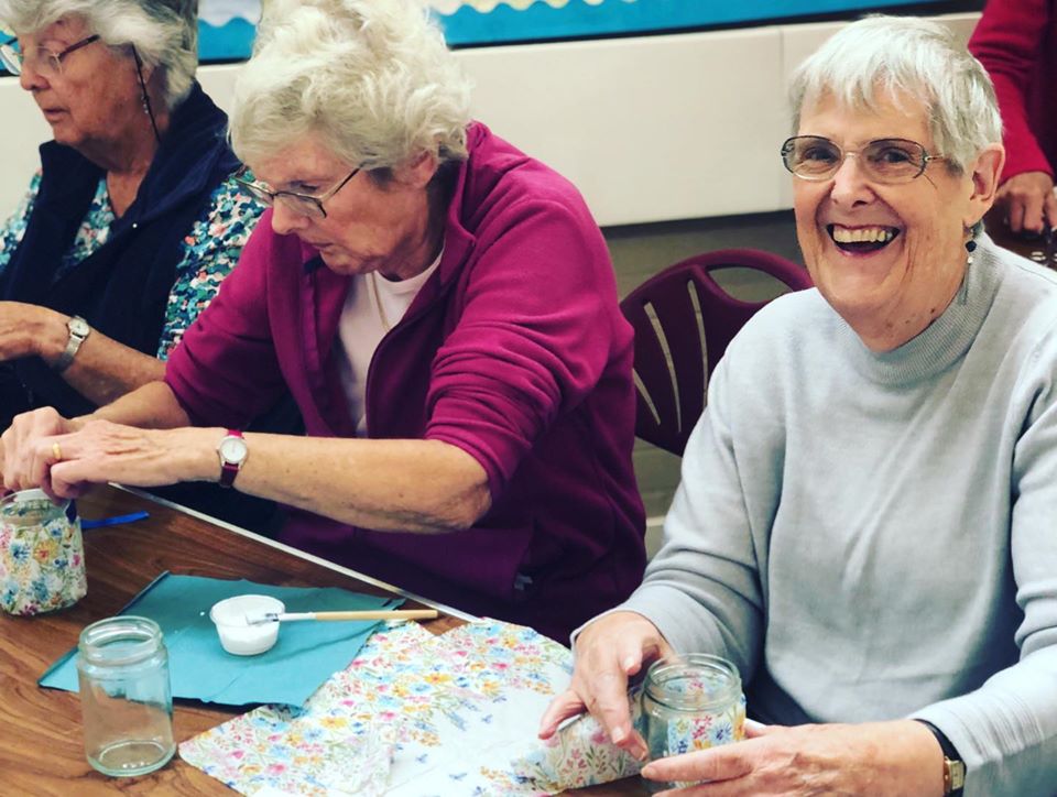 Three older ladies taking part in an activity organised by Age Concern Bracknell